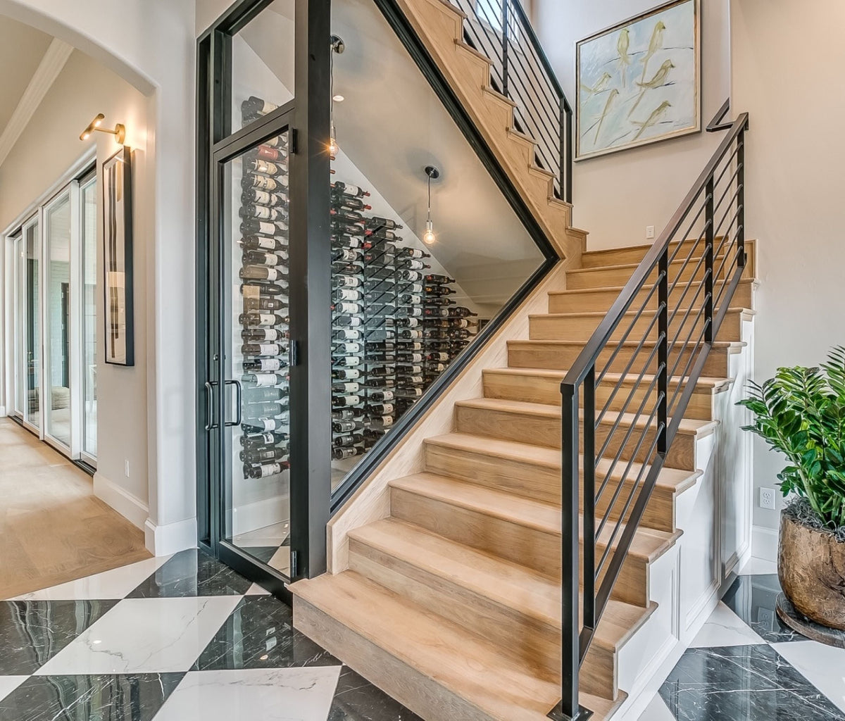 Staircase with black railings in a home interior with a wine cellar.