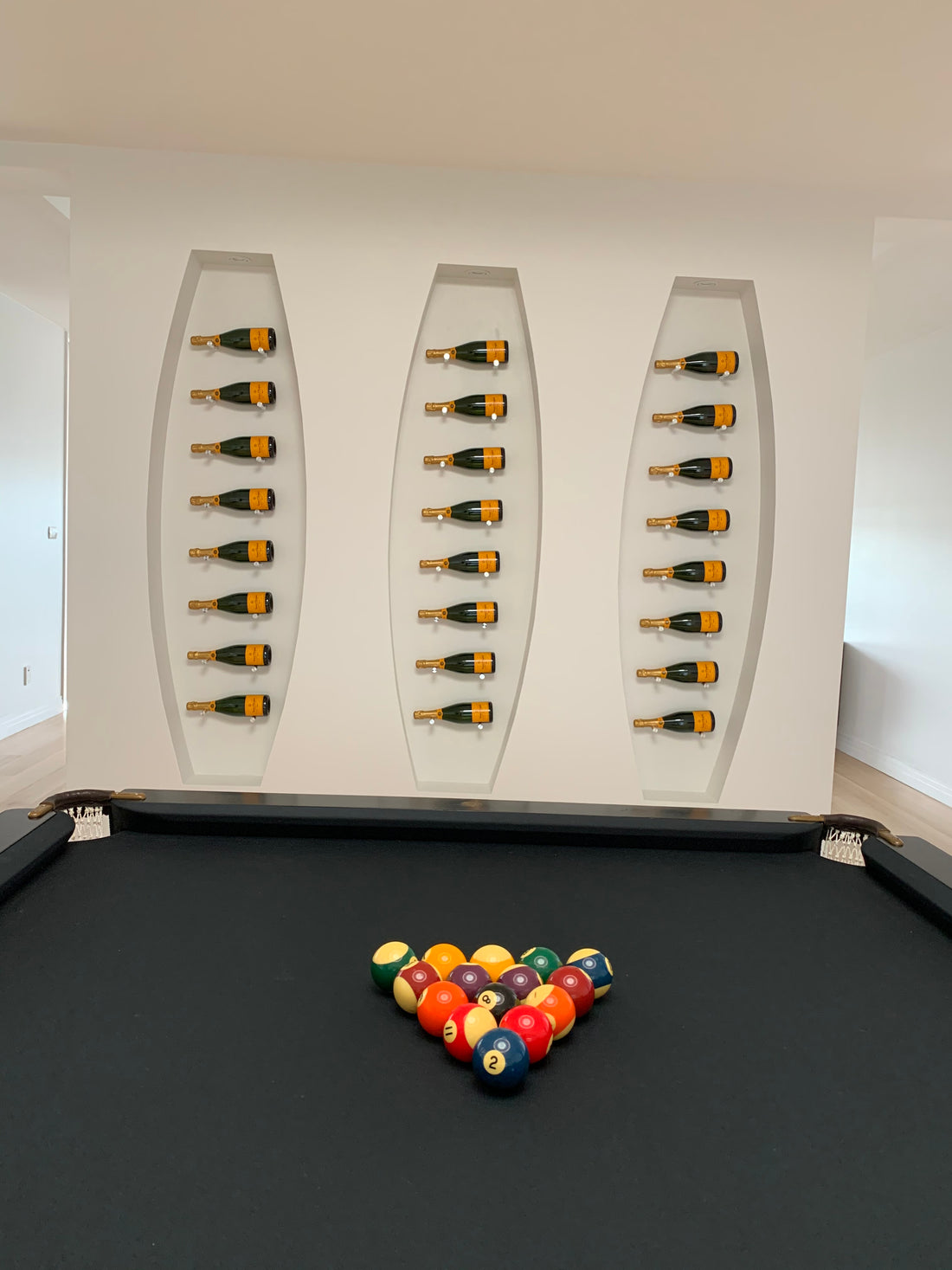 Champagne bottles on side on wall display in pool room