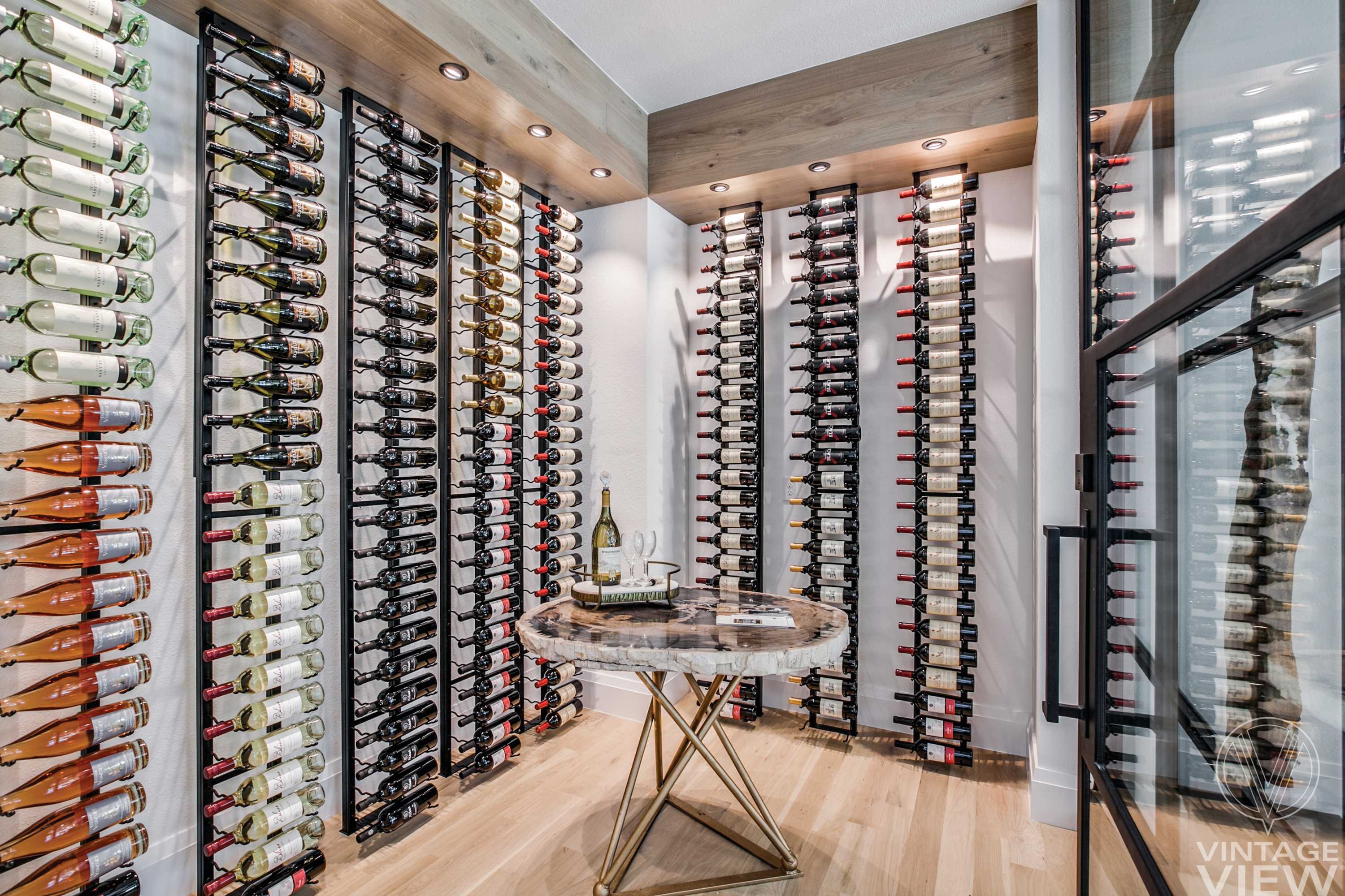 Light airy wine cellar with freestanding frames in black metal