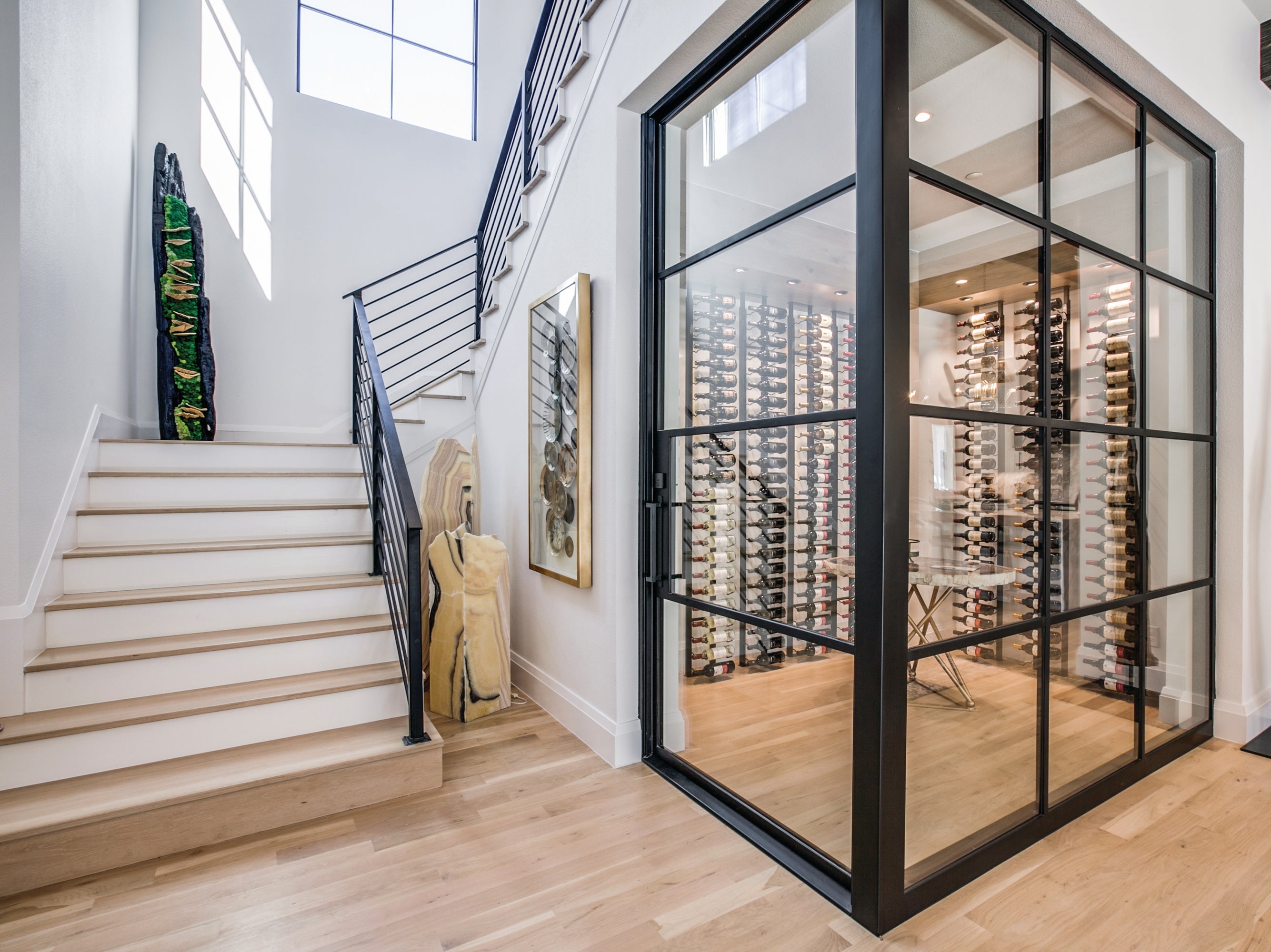 Modern interior with staircase, glass doors, and wine cellar.