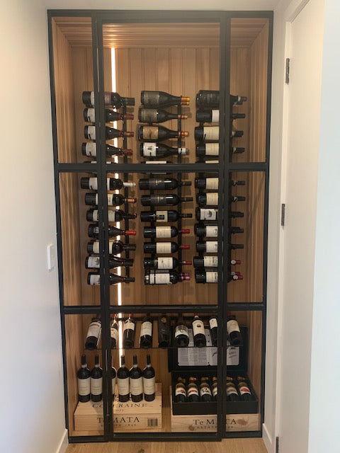 Presentation Row for special wine bottles on display in home cellar with wooden walls