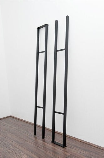 Wine Rack Floor to Ceiling from in black standing against a wall